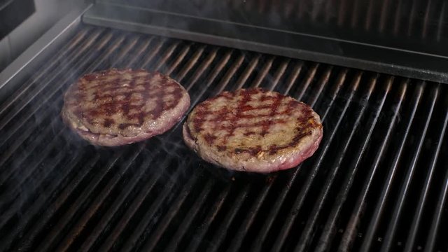 Preparing a batch of ground beef patties or frikadeller on grill or BBQ