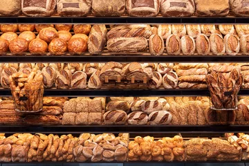 Abwaschbare Fototapete Brot Bäckereiregal mit vielen Brotsorten. Leckere deutsche Brotlaibe in den Regalen