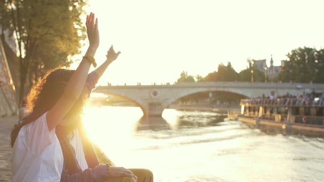 Couple waving hands at sunset in Paris, France