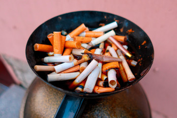 cigarette butts filled with water in a street ashtray