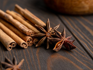 Obraz na płótnie Canvas anise stars and cinnamon sticks tied up with rope on wooden brown background
