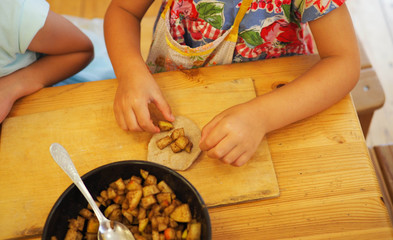children work together to roll out dough .