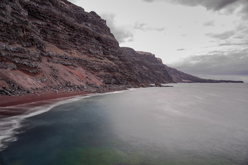 Verodal beach, red volcanic sand beach, long exposure photography, grey clouds sky,  Atlantic ocean, El Hierro, Canary islands, Spain