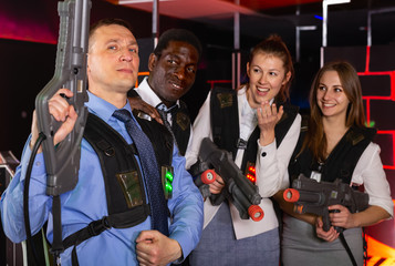 Group of happy co-workers holding laser guns