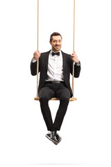 Elegant man in a suit sitting on a wooden swing