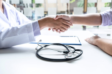 Doctor and patient shaking hands after checking with consultation and diagnosis to treatment talking about medical examination results in the clinic room