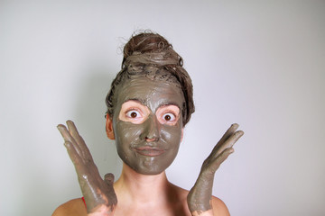 Young girl made a mask of dead sea mud for face and hair - obrazy, fototapety, plakaty