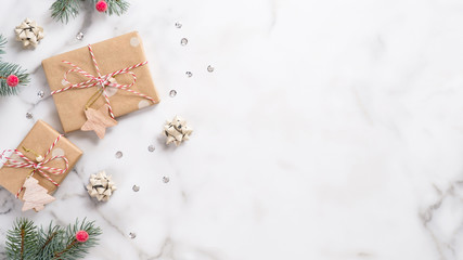 Christmas or New Year banner. Xmas greeting card. Christmas gifts and fir tree branches on white marble background. Flat lay, top view