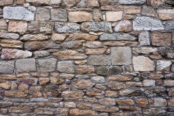 Texture of a stone wall. Old castle stone wall background. Wall made of wild stone. Natural background.