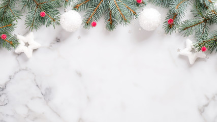 Christmas or New year banner. Pine tree branches, red berry, white balls on marble background top...