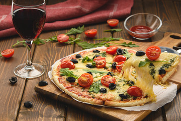 Pizza with wine tomatoes cheese and arugula