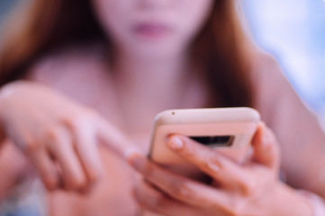 A young woman using an smartphone indoor