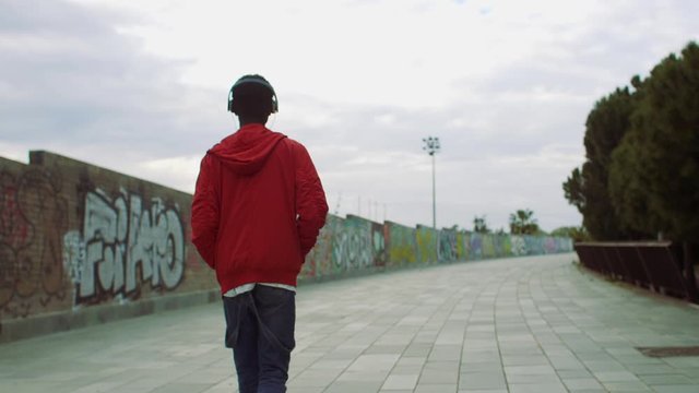 Young man walking with headphones