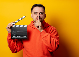 man with clapper on yellow background