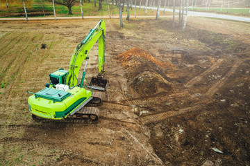 The modern excavator performs excavation work on the farm field