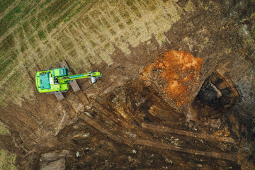 Fototapeta na wymiar The modern excavator performs excavation work on the farm field