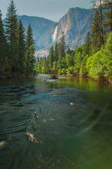 View of Yosemite Falls from the bridge above Merced River in Yosemite Valley National Park,...