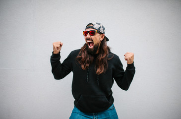 Happy hipster man celebrates victory after winning at an online bookmaker or casino. Crazy...
