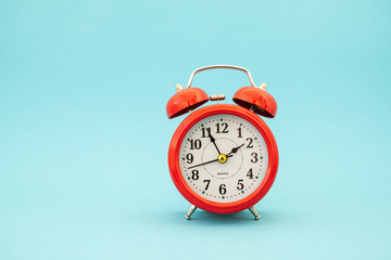 red alarm clock on blue background