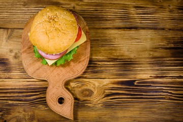 Fresh hamburger on a wooden cutting board. Top view