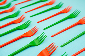 green and red plastic forks on blue background