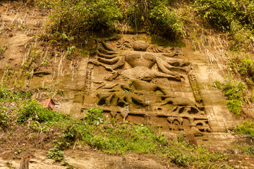 An ancient sculpture of the Hindu goddess Durga carved on the steep mountain wall around the...