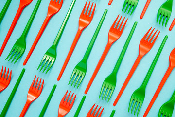 green and red plastic forks on blue background