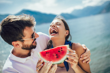 Portrait of happy couple enjoying watermelon on summer holiday
