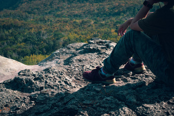 Naklejka premium teen girl stay and sitting on nature cliff with forest lanscape background, adventure trip tourism, holiday vacation with travel to moutain