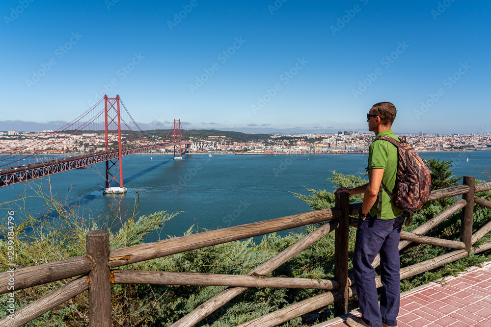 Wall mural A male tourist contemplates a view of the bridge on April 25 in Lisbon.