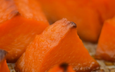  Pieces of sweet pumpkin baked with sugar for Halloween dinner. Healthy Vegetarian food. Autumn warm dish as a dessert. Selective focus, close-up. copy space.