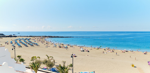  Panoramic view of crowd of people sunbathing on sandy beach of Playa de los Cristianos, enjoy warm weather, Tenerife, Canary Islands, Spain