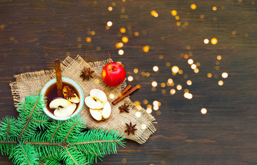 Christmas background. Hot mulled wine with ingredients in cup on wooden background. The concept of...