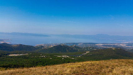 Obraz premium Mountain and hills landscape with the the sea and sky in the background. Tuhobić, Hreljin, Croatia