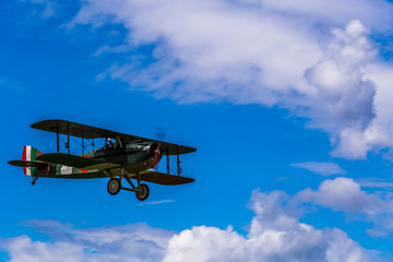 Flying biplane replica from first world war between the clouds. © Lukreo