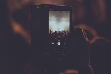 Audience at a concert and recording on the phone.