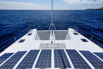 Luxury solar powered catamaran, fully sustainable and powered by solar energy, charging batteries aboard a sailboat, vessel in ocean waters, nobody. Photovoltaic panels renewable eco energy concept - obrazy, fototapety, plakaty