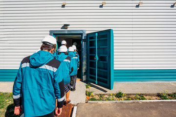 Factory workers entering to armored door of bomb shelter