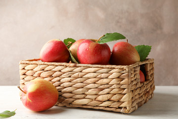 Basket with apples on white wooden background, copy space