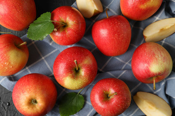 Apples and kitchen towel on black background, top view