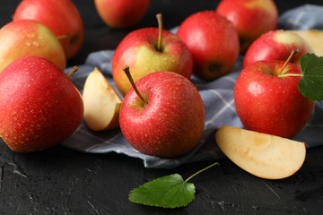 Apples and kitchen towel on black background, close up