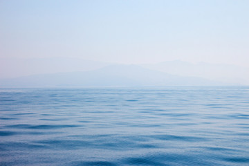 view of the coast and mountains from the sea in the morning fog