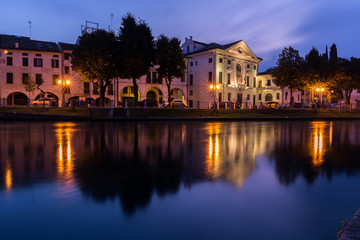 Picturesque view on the Sile river in the city center with lights reflections on the water at night Treviso Italy