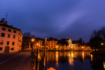 Plakat Picturesque view on the Sile river in the city center with lights reflections on the water at night Treviso Italy