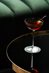 Classic cocktail glass on glass table in night club restaurant, close-up