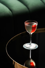 Classic cocktail glass on glass table in night club restaurant, close-up