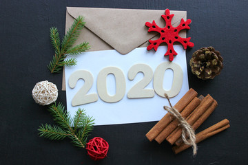 2020. New year, Christmas composition. The numbers 2020, the concept of new year greetings. Christmas tree, cocoa, Christmas decorations on a black background, bokeh, snowflakes.