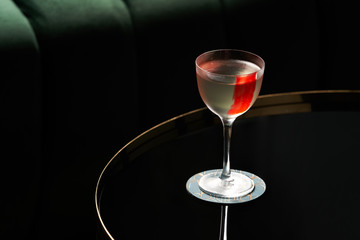 Classic cocktail glass on glass table in night club restaurant, close-up