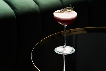 Classic cocktail glass on glass table in night club restaurant, close-up