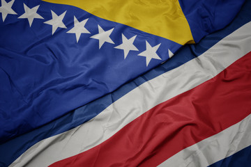 waving colorful flag of costa rica and national flag of bosnia and herzegovina.